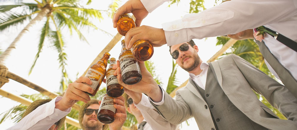 A group of men celebrating with some beers who met each other through getting tantric massages