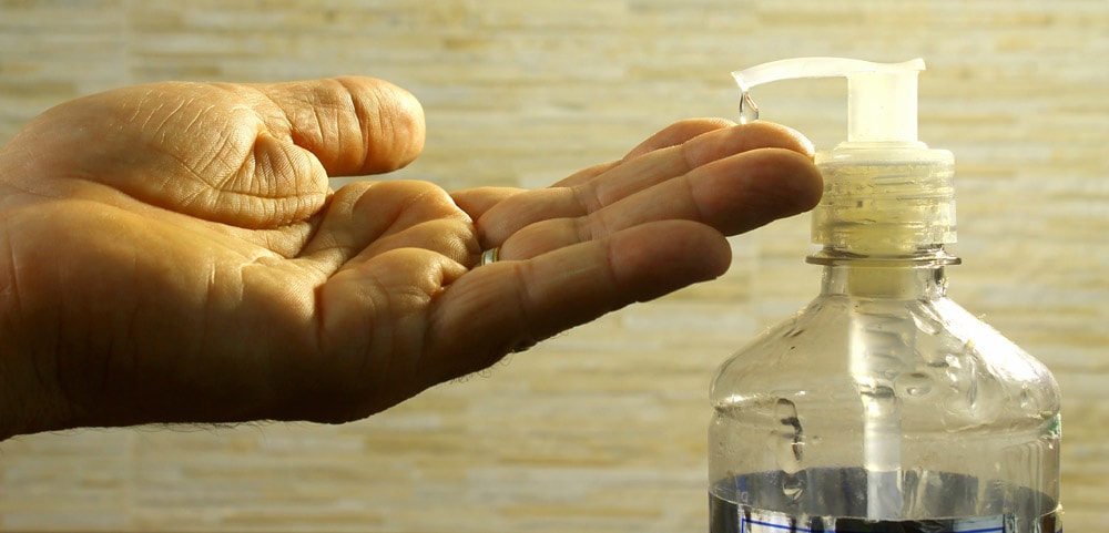 A massage therapist squirting some nuru gel into their hand