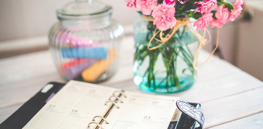 A diary next to a bunch of flowers